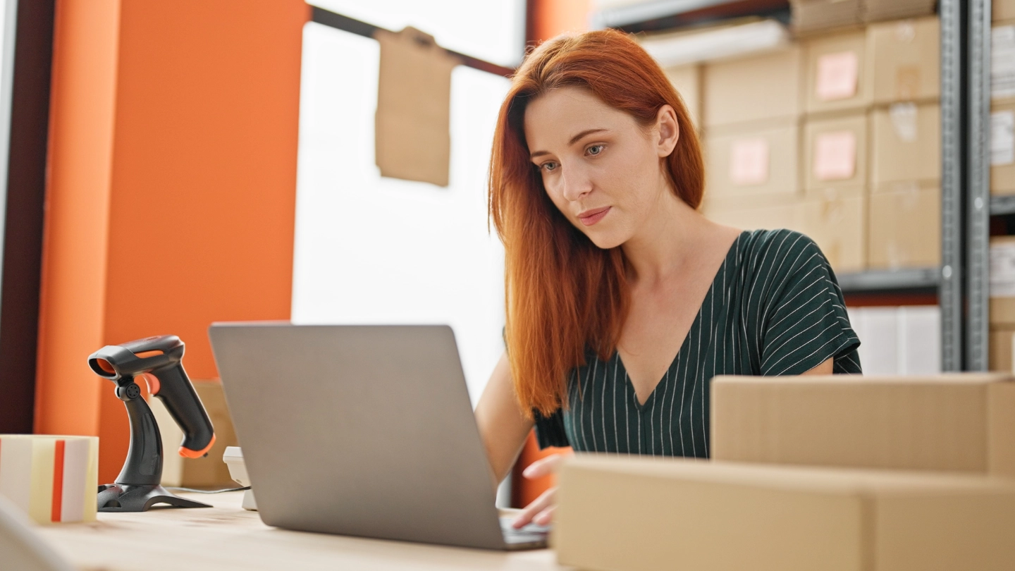 Young redhead woman using laptop at office image
