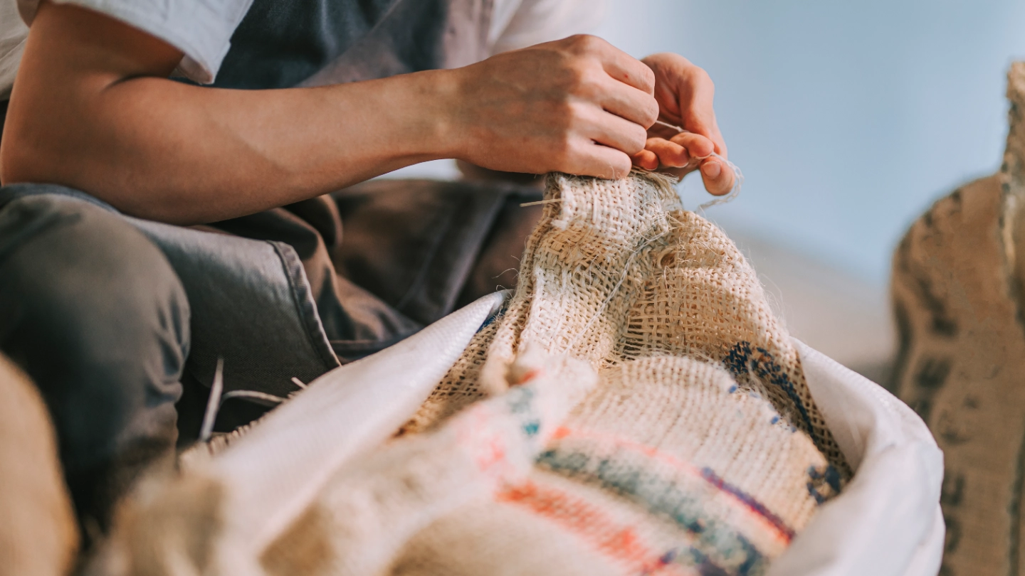 Coffee bean worker fixing a sack