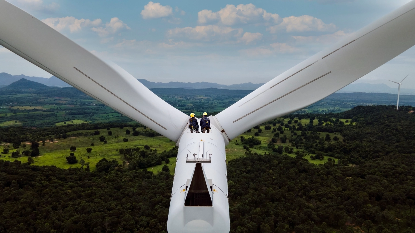 Two workers in the distance on a high level turbine Two workers in the distance on a high level turbine
