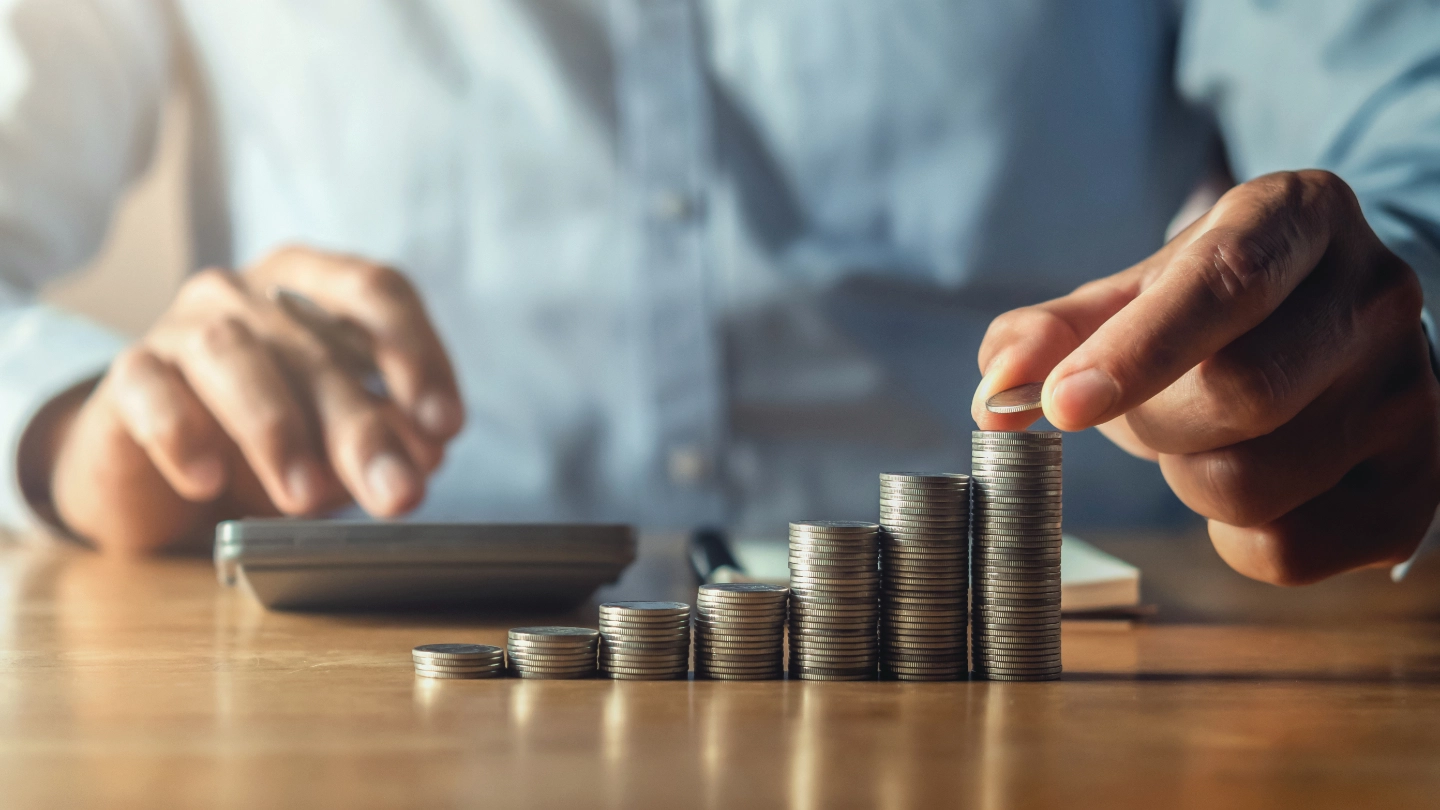 Money piles saving money with hand putting coins on stack concept financial