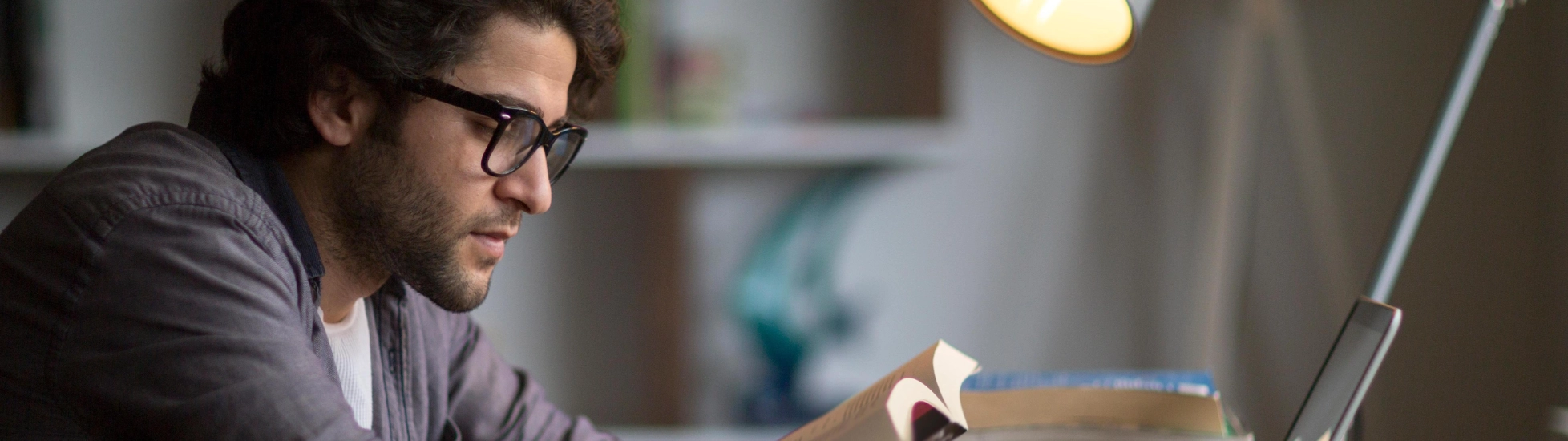 Knowledge and researching zoomed in image of man reading and using laptop